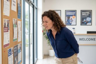 Femme regardant un tableau d'affiches dans un centre de formation